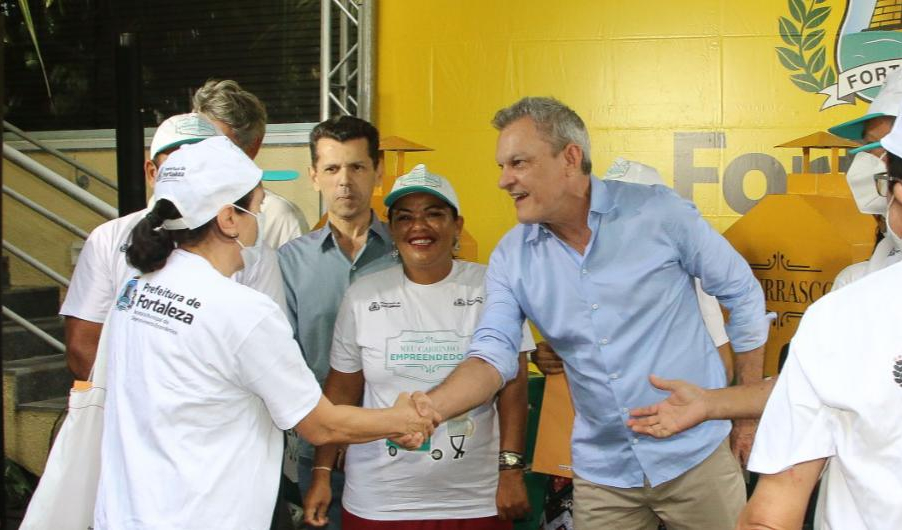 prefeito cumprimenta uma pessoa durante a solenidade